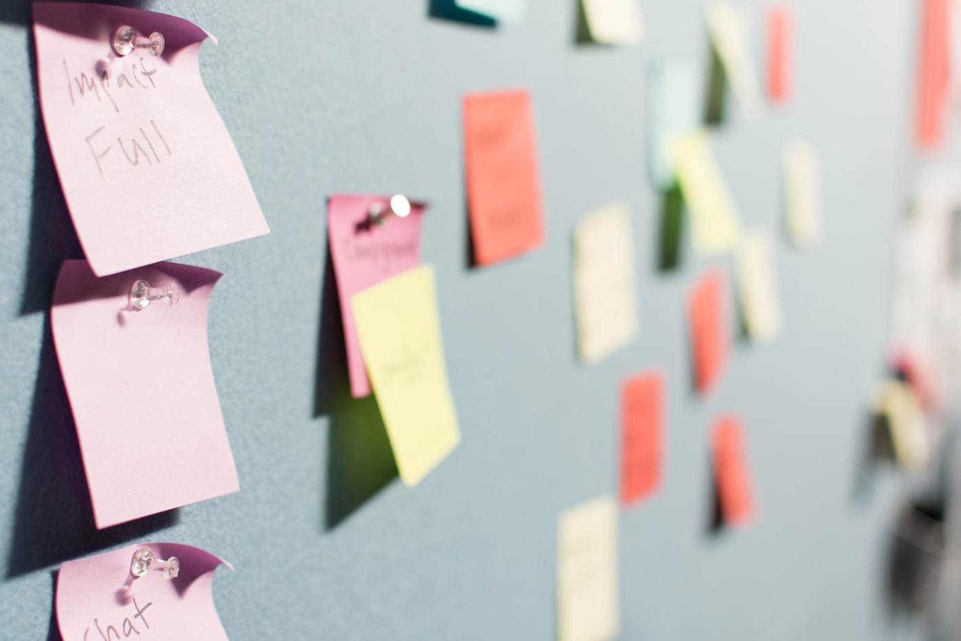 Pink, yellow and green notes pinned across a planning board.